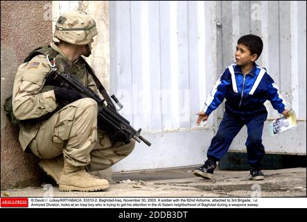 PAS DE FILM, PAS DE VIDÉO, PAS DE TV, PAS DE DOCUMENTAIRE - © DAVID P. GILKEY/KRT/ABACA. 53310-2. Bagdad-Iraq, 30 novembre 2003. Un soldat de la 82e aéroportée, attaché à la 3e Brigade de la 1re Division blindée, regarde un garçon irakien qui tente d'attirer son attention dans le quartier Al Salam de Bagdad pendant Banque D'Images