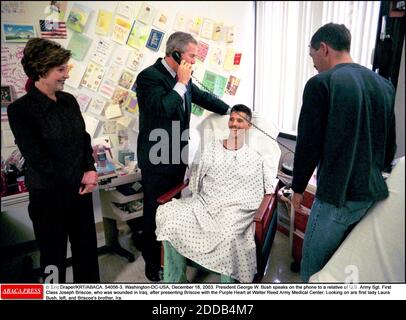 PAS DE FILM, PAS DE VIDÉO, PAS DE TV, PAS DE DOCUMENTAIRE - © ERIC DRAPER/KRT/ABACA. 54056-3. Washington-DC-USA, 18 décembre 2003. Le président George W. Bush parle au téléphone à un parent du sergent de l'armée américaine. Première classe Joseph Briscoe, qui a été blessé en Irak, après avoir présenté Briscoe avec le coeur pourpre à Wal Banque D'Images