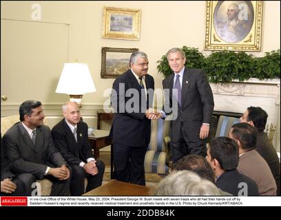 PAS DE FILM, PAS DE VIDÉO, PAS de TV, PAS DE DOCUMENTAIRE - dans le Bureau ovale de la Maison Blanche, 25 mai 2004, Le président George W. Bush rencontre sept Irakiens qui ont tous eu les mains coupées par le régime de Saddam Hussein et qui ont récemment reçu un traitement médical et des mains prothétiques aux États-Unis photo de Chuck Kennedy/KRT/ABACA. Banque D'Images