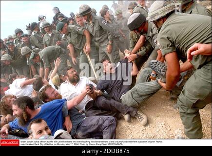 PAS DE FILM, PAS DE VIDÉO, PAS de télévision, PAS DE DOCUMENTAIRE - les agents de la police des frontières israélienne se sont raclés à des colons juifs qui bloquaient le démantèlement de l'avant-poste non autorisé de Mitzpeh Yitzhar, près de la ville de Naplouse en Cisjordanie, le lundi 17 mai 2004. Photo de Sharon Perry/Flash 90/KRT/ABACA. Banque D'Images