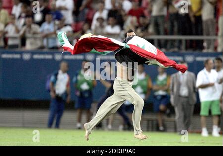 PAS DE FILM, PAS DE VIDÉO, PAS de télévision, PAS DE DOCUMENTAIRE - un fan irakien court sur le terrain avec un drapeau alors que l'Irak fait face au Costa Rica dans le football le dimanche 15 août 2004, dans les Jeux Olympiques à Athènes, Grèce. Photo par Ron Cortes/KRT/ABACA. Banque D'Images