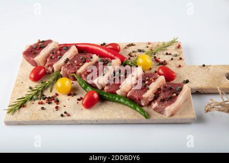 Kebab de shish cru. Steak d'agneau cru servi sur une planche à découper en pierre avec sel de mer et flocons de poivre, romarin et menthe. Banque D'Images