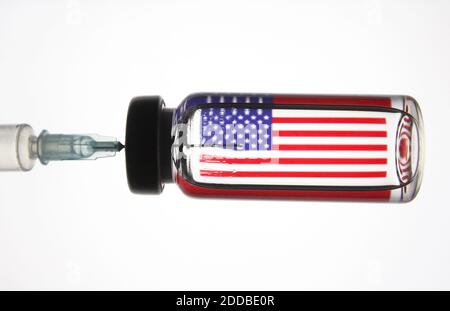 Sur cette photo, une seringue médicale et un flacon représentant le vaccin contre le coronavirus vus devant le drapeau américain. Banque D'Images