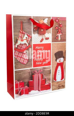 Image couleur horizontale avec vue de face d'un sac de Noël rouge en papier décoré de bonhomme de neige et présente sur fond blanc. Nouveau Banque D'Images