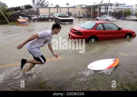 PAS DE FILM, PAS DE VIDÉO, PAS de télévision, PAS DE DOCUMENTAIRE - Scott Bolan se prépare à monter sur son tableau de skim dans une rue inondée à Key West, Floride, après que l'oeil de l'ouragan Dennis est passé à l'ouest de Key West le samedi 9 juillet 2005. Photo par Andrew Innerarity/KRT/ABACAPRESS.COM. Banque D'Images