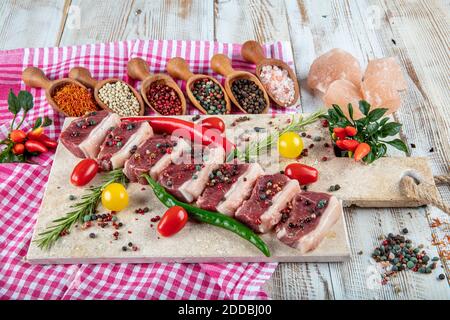 Kebab de shish cru. Steak d'agneau cru servi sur une planche à découper en pierre avec sel de mer et flocons de poivre, romarin et menthe. Banque D'Images