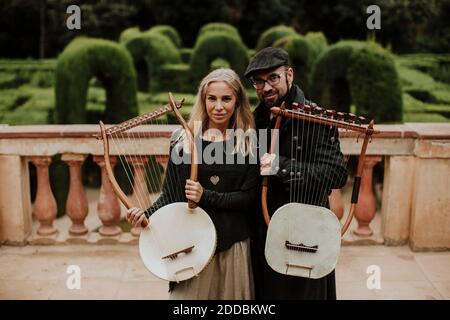 Homme et femme partenaire tenant l'instrument lyra dans le parc public Banque D'Images