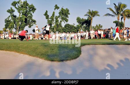 PAS DE FILM, PAS DE VIDÉO, PAS de TV, PAS DE DOCUMENTAIRE - Tiger Woods (à gauche) aligne sa mise sur le 17ème trou comme Daniel Chopra (chemise rouge) part à droite, au Ford Championship à Doral, FL, USA, le 5 mars 2006. Woods a gagné le tournoi par un seul coup. Photo de John VanBeekum/Miami Herald/KRT/ABACAPRESS.COM Banque D'Images