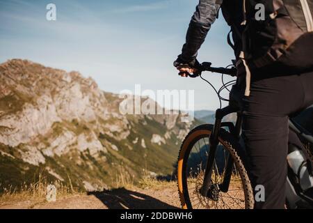 Motard de montagne femelle sur vélo électrique debout contre la montagne au parc naturel de Somiedo, Espagne Banque D'Images