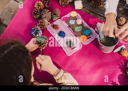 Les sœurs colorent les cônes de pin tout en décorant à la table de pique-nique stationnement Banque D'Images