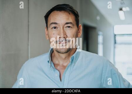 Beau homme d'affaires debout dans le couloir Banque D'Images