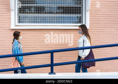 Des amies des femmes dansant en se tenant debout au mur sous le soleil jour Banque D'Images