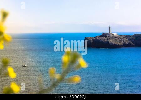 Vue sur l'île et le phare de Mouro - Isla y Faro de Mouro - et un petit bateau. Santander, Espagne Banque D'Images