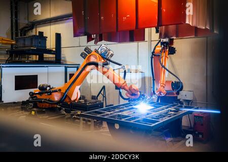 Soudage des bras robotisés orange dans l'industrie Banque D'Images