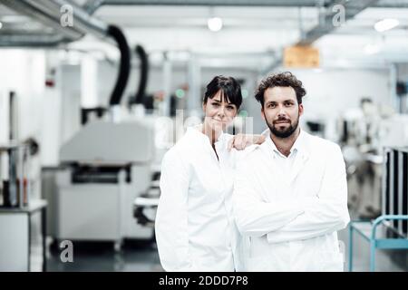 Hommes et femmes scientifiques en blouse de laboratoire blanche debout à laboratoire lumineux Banque D'Images
