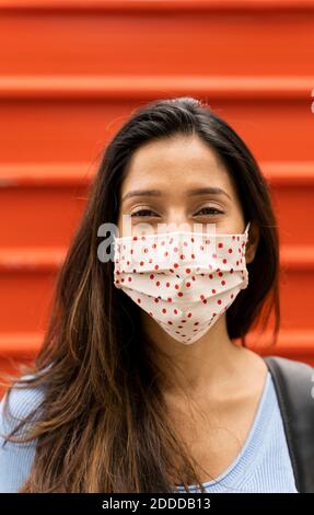 Femme souriante avec masque de protection contre l'obturateur pendant COVID-19 Banque D'Images