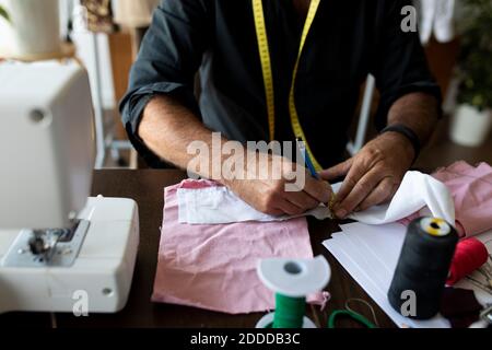 Marquage masculin sur mesure sur le tissu avec crayon dans le studio de travail Banque D'Images