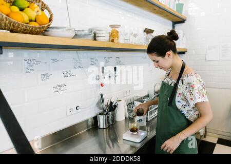 Le barista prépare un café froid en se tenant dans la cuisine à café-restaurant Banque D'Images