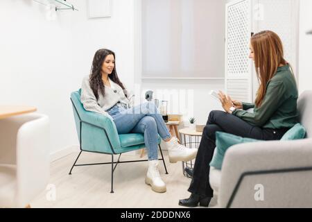 Psychologue parlant au patient assis sur le canapé au bureau Banque D'Images