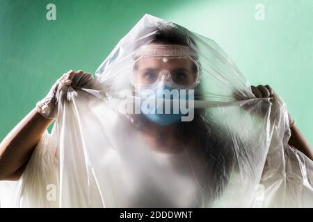 Femme portant un masque de protection recouvert de plastique pendant le coronavirus Banque D'Images