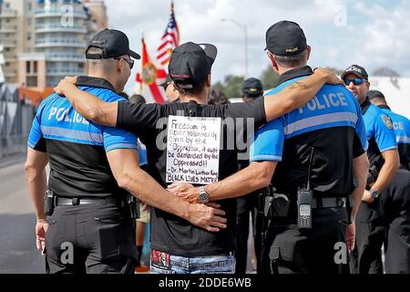 PAS DE FILM, PAS DE VIDÉO, PAS de TV, PAS DE DOCUMENTAIRE - Anthony Wallace, au centre, est adopté par deux policiers de Miami Beach lors de la parade annuelle du MLK lundi 16 janvier 2017 à Miami, FL, USA. Photo de Patrick Farrell/Miami Herald/TNS/ABACAPRESS.COM Banque D'Images