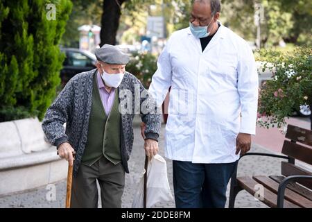 Homme mature avec homme senior portant un masque de protection de marche à l'extérieur Banque D'Images
