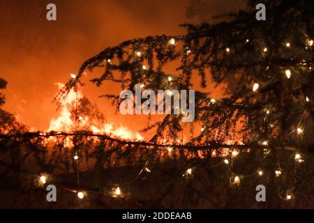 PAS DE FILM, PAS DE VIDÉO, PAS de télévision, PAS DE DOCUMENTAIRE - des flammes brûlent derrière un grand arbre décoré de lumières de Noël au centre commercial River Village à l'autoroute 76 et South Mission Road alors que le feu Lilac brûle à travers Bonsall, CA, USA, le jeudi 7 décembre 2017. Photo de Hayne Palmour IV/San Diego Union-Tribune/TNS/ABACAPRESS.COM Banque D'Images