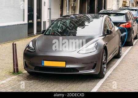Amsterdam, pays-Bas - Mars 2020 : Tesla voiture électrique moderne est garée à la station de charge dans la rue dans la ville européenne.Tesla - société américaine, fabricant de véhicules électriques et pas seulement. Banque D'Images