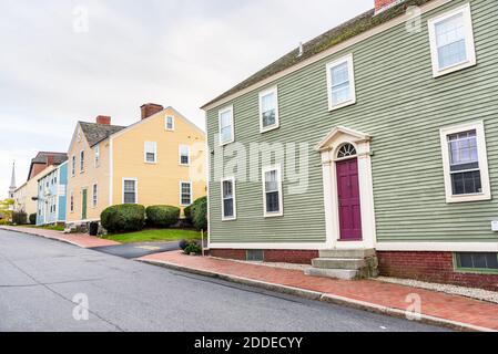 Maisons traditionnelles en bois pastel le long d'un trottoir en briques sur un nuageux jour d'automne Banque D'Images