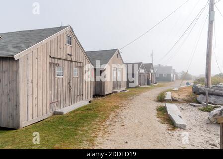 Rangée de cabanes de pêcheurs en bois le long d'un sentier de la côte sablonneuse un jour d'automne brumeux Banque D'Images