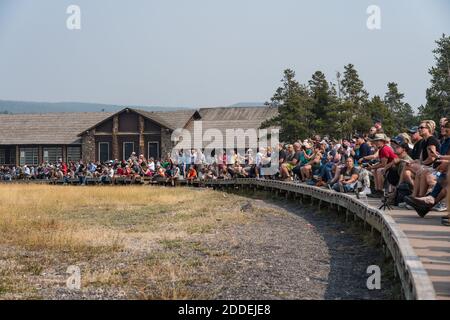 Les touristes attendent que le geyser Old Faithful éclate en face de l'Old Faithful Lodge dans le parc national de Yellowstone dans le Wyoming, Etats-Unis. Banque D'Images