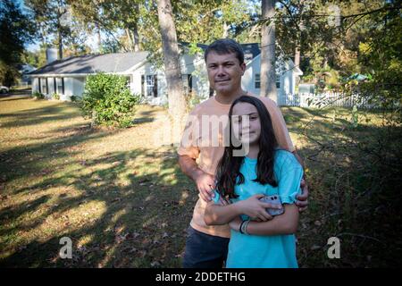 Albany, Géorgie, États-Unis. 12 novembre 2020. Chad Holland, Albany, GA propriétaire d'une maison, qui est en colère par la pratique de Georgia Power de vider de l'eau de charbon remplie de cendres dans un étang de décantation non doublé près de sa maison que la zone contaminée approvisionnement en eau souterraine.photo: Hollande discute avec sa fille plus jeune Madison, 12, devant leur maison crédit: Robin Rayne/ZUMA Wire/Alay Live News Banque D'Images