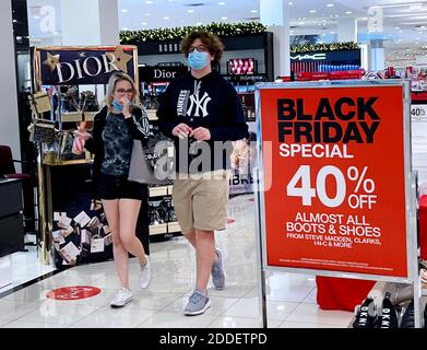 Orlando, États-Unis. 24 novembre 2020. Les acheteurs portant un masque facial se prominent devant un panneau de vente du Vendredi fou dans un magasin du Mall de Millenia, tandis que les marchands se préparent à l'une des journées de magasinage les plus achalandées de l'année. De nombreux détaillants ont commencé leurs ventes des fêtes au début de l'année en raison de la pandémie, espérant réduire le nombre de personnes qui se bousculaient en toute sécurité dans les magasins le lendemain de Thanksgiving. Crédit : SOPA Images Limited/Alamy Live News Banque D'Images