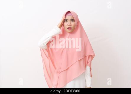 Portrait de panique choquée femme musulmane asiatique portant un voile ou un hijab tenant les mains sur la tête. Isolé sur fond blanc avec espace de copie Banque D'Images