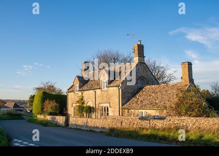 Maison en pierre de Cotswold en automne après-midi lumière du soleil dans le village de Sherborne, Cotswolds, Gloucestershire, Angleterre Banque D'Images