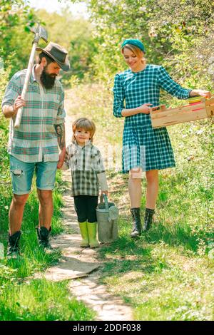 Bonne famille à la ferme. Jour de la terre. Belle jeune famille souriante s'amuser dans la cour de la ferme. Concept de la Terre. Jeune famille avec enfant s'amuser dans la nature. Banque D'Images