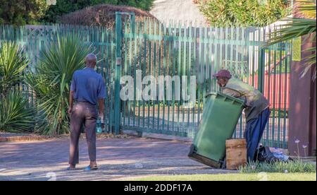 Alberton, Afrique du Sud - des personnes non identifiées creusent dans des poubelles résidentielles pour la nourriture et les articles utiles Banque D'Images