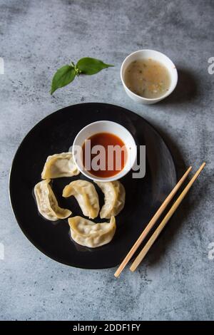 Mets tibétains momos dans une assiette avec condiments Banque D'Images