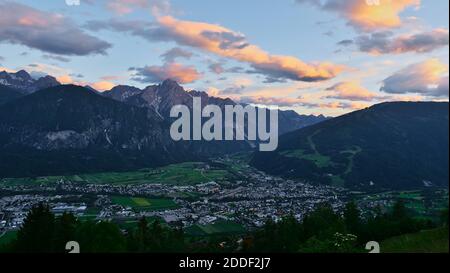 Belle vue panoramique de la ville de Lienz dans le Tyrol, Autriche dans la vallée après le coucher du soleil dans la lumière du soir avec nuages illuminés dans le ciel. Banque D'Images