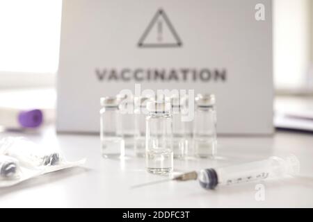 Seringues et flacons en verre avec vaccin antiviral moderne table d'hôpital blanche Banque D'Images