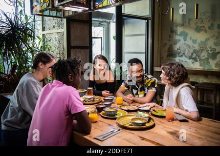 Groupe d'amis assis et prenant un repas dans un café. Banque D'Images