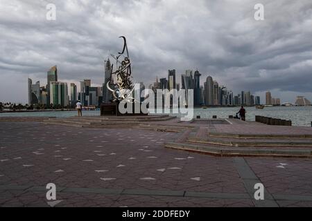 Doha Qatar vue sur le coucher du soleil avec des nuages dans le ciel Affichage des gratte-ciels et des huarts en arrière-plan et de la sculpture de calligraphie dans premier plan Banque D'Images