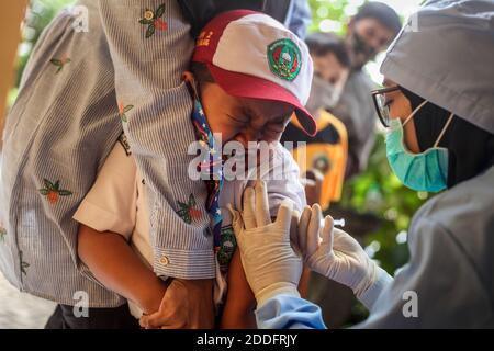 Un travailleur de la santé qui injecte un étudiant pendant la vaccination. Programme d'immunisation en matière de santé scolaire les agents de santé injectent le vaccin contre la diphtérie tétanique (DT) aux élèves pendant le mois d'immunisation scolaire des enfants (PARTIALITÉ) à AU MOINS 2, afin de protéger la santé des enfants contre la maladie et d'augmenter l'immunité corporelle pendant la pandémie de covid-19. Banque D'Images