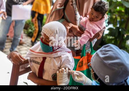 Un travailleur de la santé qui injecte un étudiant pendant la vaccination. Programme d'immunisation en matière de santé scolaire les agents de santé injectent le vaccin contre la diphtérie tétanique (DT) aux élèves pendant le mois d'immunisation scolaire des enfants (PARTIALITÉ) à AU MOINS 2, afin de protéger la santé des enfants contre la maladie et d'augmenter l'immunité corporelle pendant la pandémie de covid-19. Banque D'Images