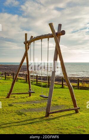 Un ensemble vide de balançoires dans un parc côtier de Fife, que nous avons rencontré le merlan sur une staycation. Les balançoires ici sont vides. Banque D'Images