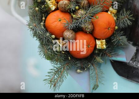 Bouquet de Noël de branches de sapin, mandarines et petites boîtes-cadeaux sur fond bleu. Nouvelle année Banque D'Images