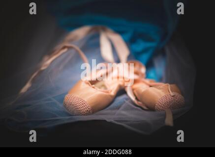 Gros plan d'une paire de chaussures de ballet de répétition roses isolées sur le costume de robe de ballet. Banque D'Images