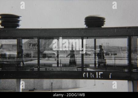 Belle photographie d'époque en noir et blanc des piétons marchant le long d'un passage fermé. Banque D'Images