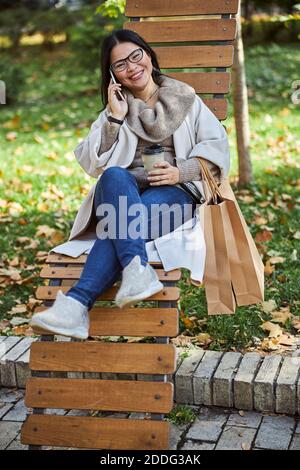 Une femme joyeuse qui a une conversation téléphonique dans la rue Banque D'Images
