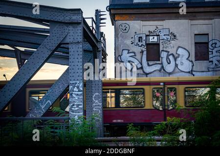 train passant devant un mur de graffiti dans un environnement urbain Banque D'Images